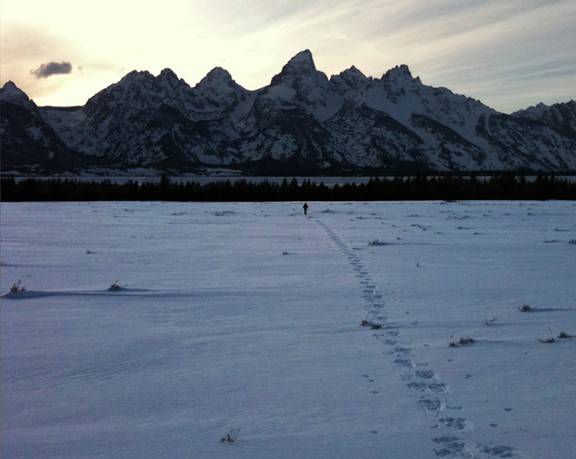 Jean Hocker snowshoeing in the mountains as the sun sets