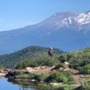 A hiker pauses at Heart Lake to admire Mt. Shasta