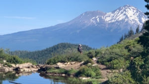 A hiker pauses at Heart Lake to admire Mt. Shasta