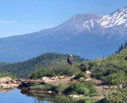 A hiker pauses at Heart Lake to admire Mt. Shasta